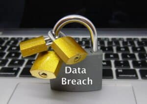 A lock on a computer with 'data breach' written on to represent data insurance protection.